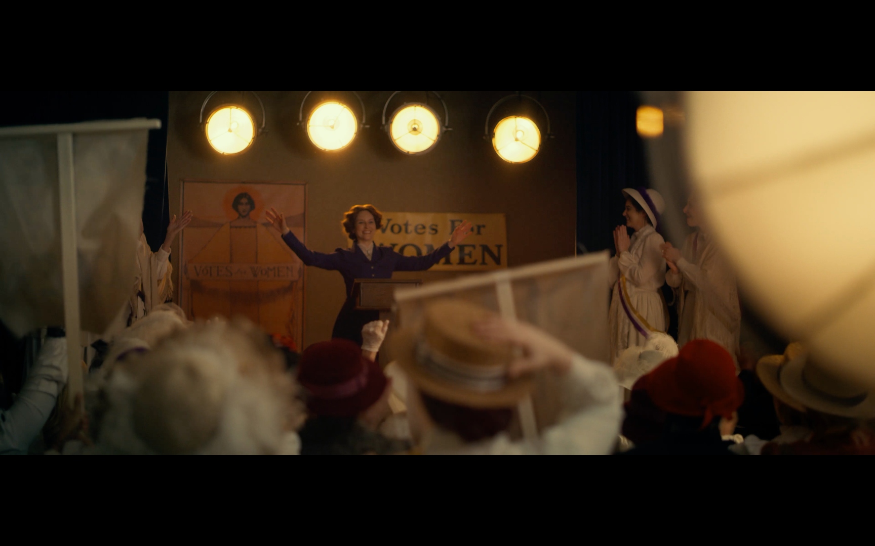 Amy Walker as Inez, addressing the crowd